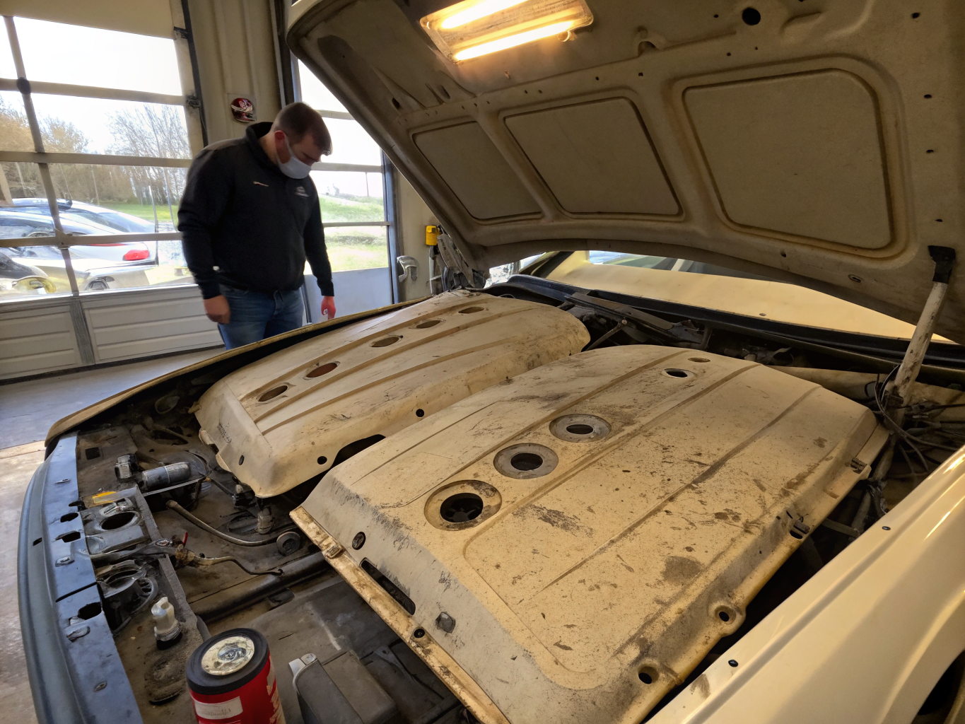 Detailed inspection of an open engine bay under bright workshop task lighting